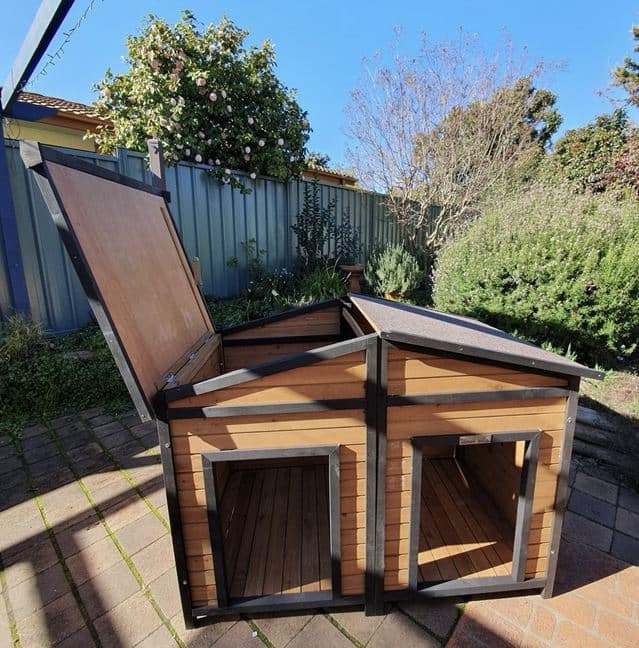 Den Dog Kennel in a backyard on pavers, with half the roof open.